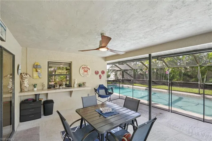 Swimming pool with a patio, a ceiling fan, and glass enclosure