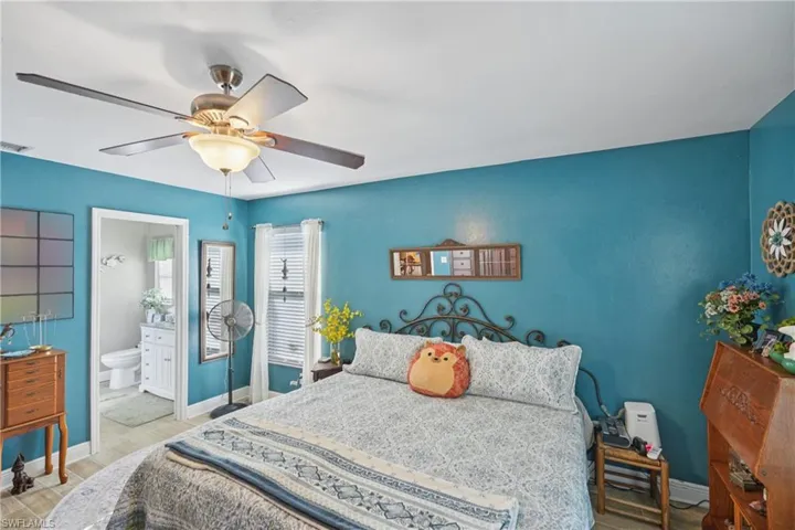 Bedroom featuring ensuite bath and a ceiling fan