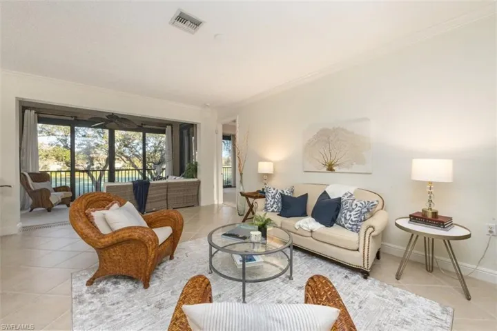 Tiled living area featuring crown molding and baseboards