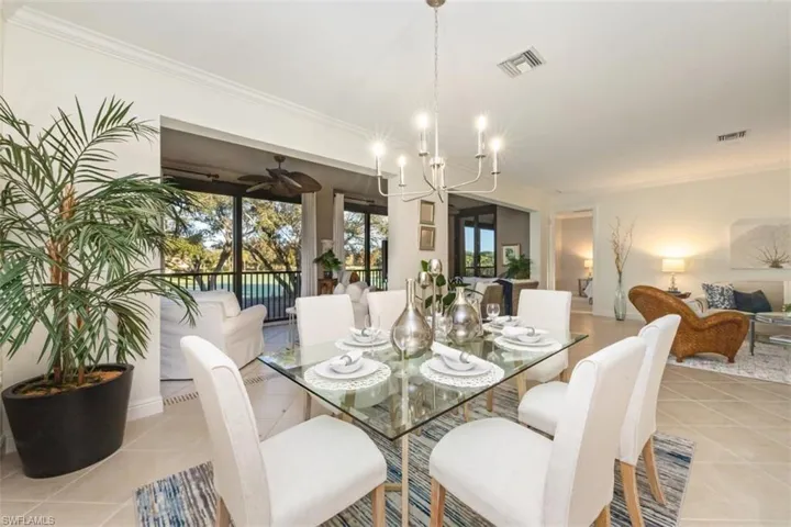 Dining area featuring a chandelier, crown molding, and light tile patterned flooring