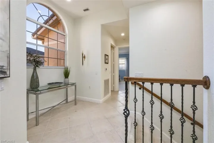 Hall with light tile patterned flooring and recessed lighting