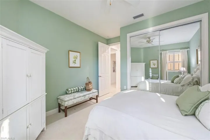 Bedroom with light carpet, a closet, and ceiling fan