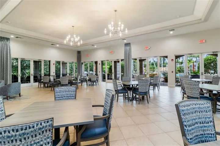 Dining area with a towering ceiling, a raised ceiling, light tile patterned floors, healthy amount of natural light, and recessed lighting