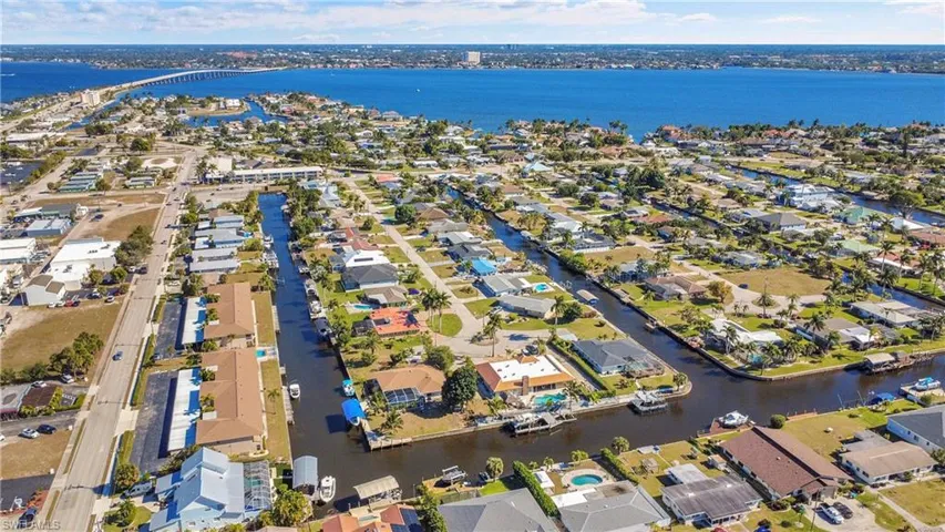Great view of newer tan shingle roofs on both buildings and Cape Coral Bridge in the background.