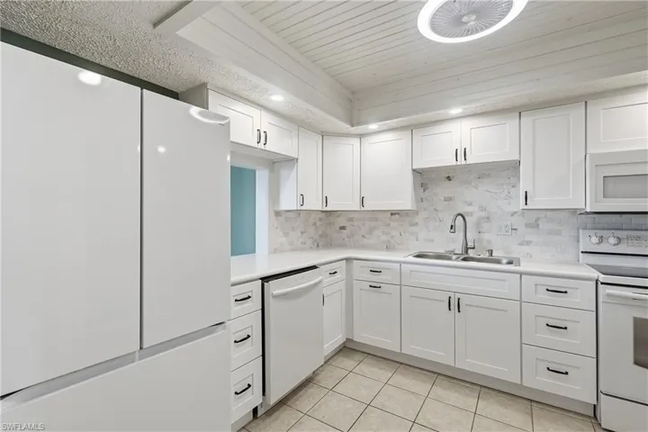 Updated kitchen features sleek appliances, all new soft-close cabinets with multiple drawers and pass through to dining.
