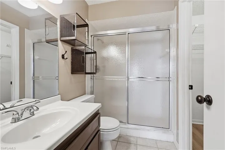 Ensuite bathroom within primary bedroom features a step-in tiled shower.