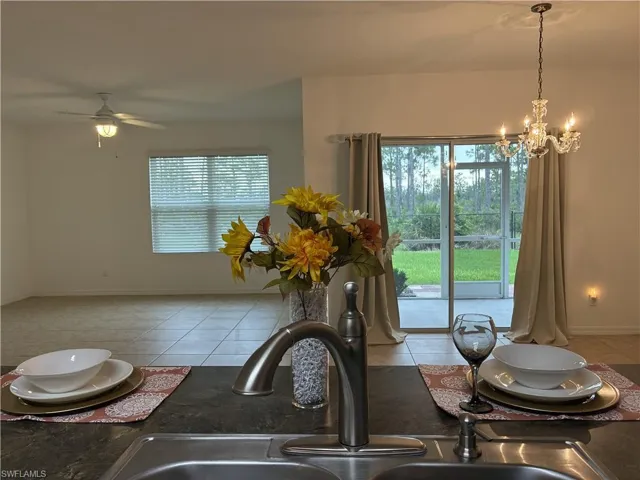 Dining space featuring light tile patterned flooring, a chandelier, and ceiling fan