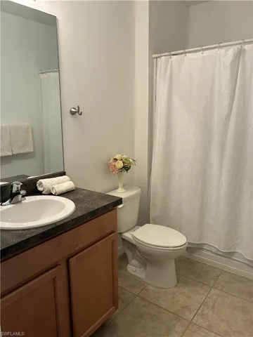 Guest Full bath featuring light tile patterned flooring, vanity, and shower / bath combo