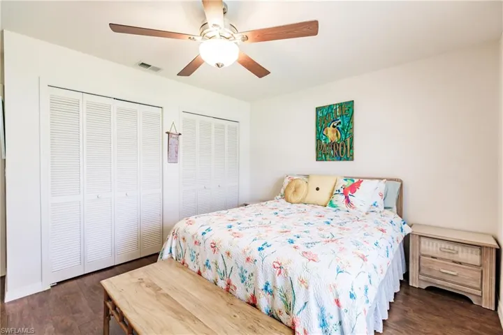 Bedroom featuring dark hardwood / wood-style floors, and multiple closets