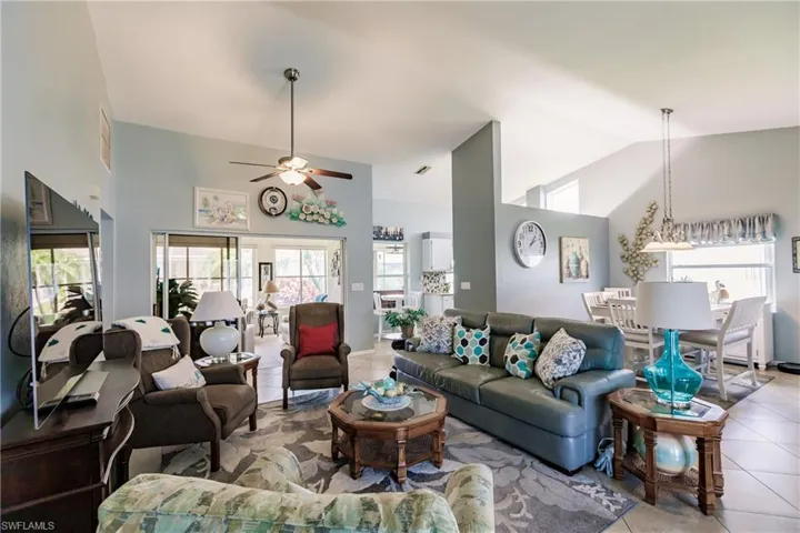Tiled living room with high vaulted ceiling and ceiling fan