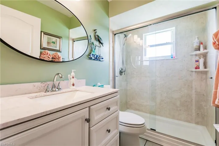 Bathroom with tile flooring, &  shower with door, and vanity