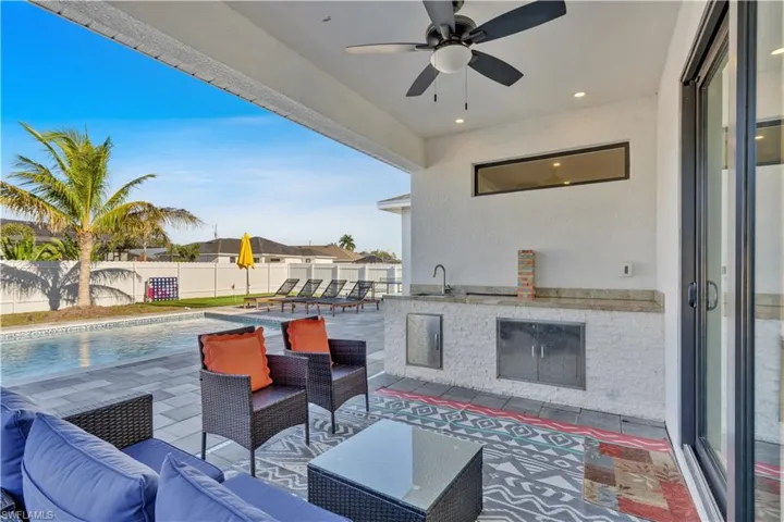 Fenced backyard with a patio area, outdoor lounge area, and ceiling fan