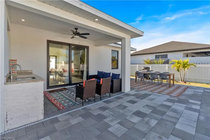 View of patio featuring outdoor dining space, ceiling fan, area for grilling, and an outdoor hangout area