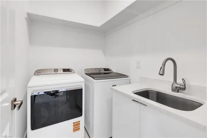 Laundry area featuring a sink and washing machine and clothes dryer
