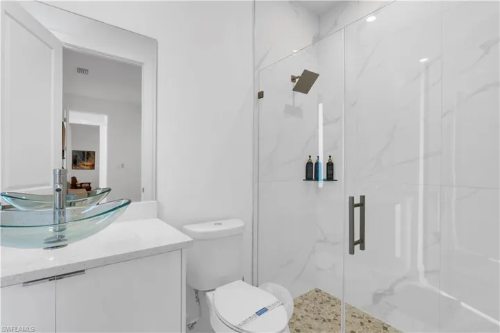 Full bathroom with vanity and a marble finish shower