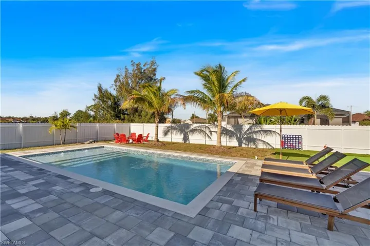 View of swimming pool with a patio and a fenced backyard