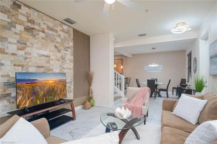 Living room featuring accent wall and ceiling fan