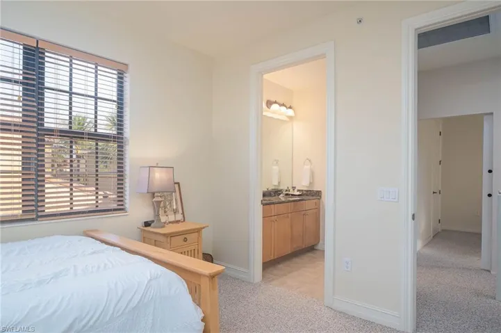 Carpeted bedroom featuring ensuite bath