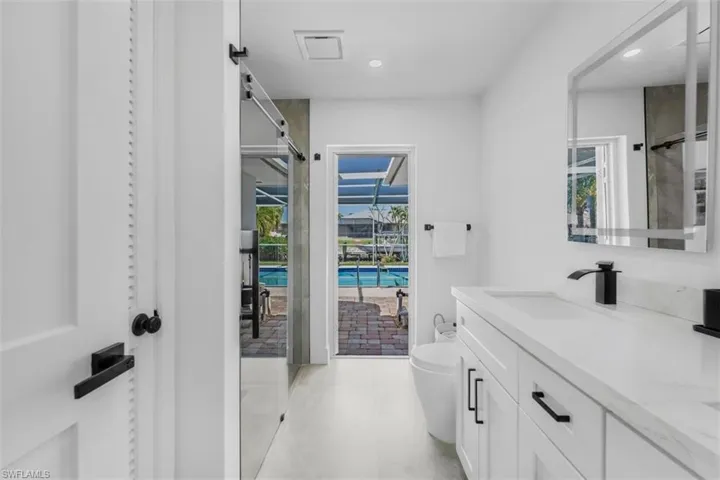Bathroom with vanity, recessed lighting, and a shower