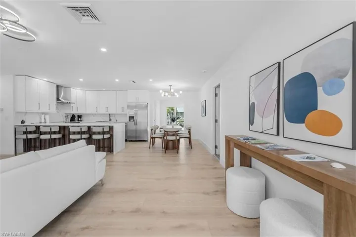 Living area with light wood finished floors and hanging lights