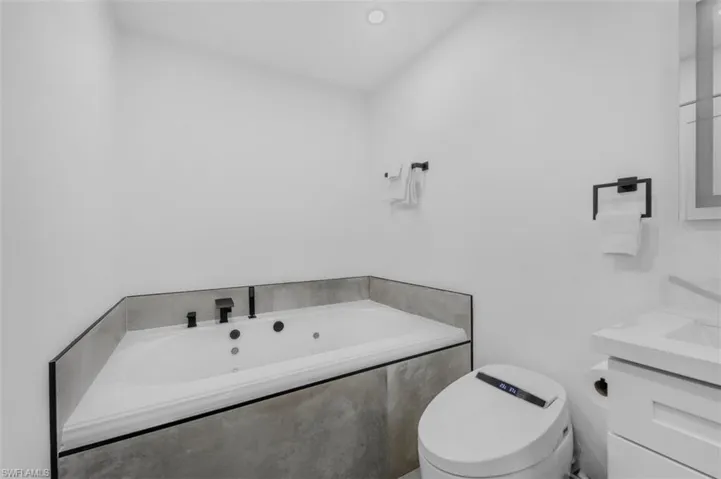 Full bathroom with vanity and a whirlpool tub
