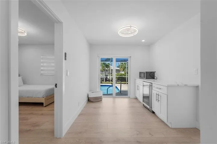 Corridor featuring light wood finished floors and wine cooler
