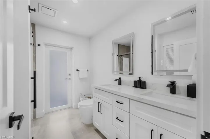 Bathroom featuring double vanity, recessed lighting, and a bidet