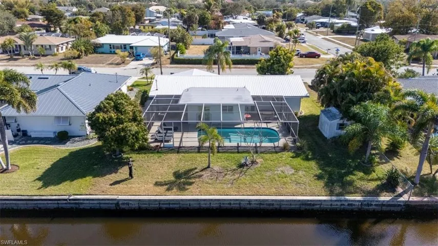 Aerial perspective of suburban area with a nearby body of water and a pool area