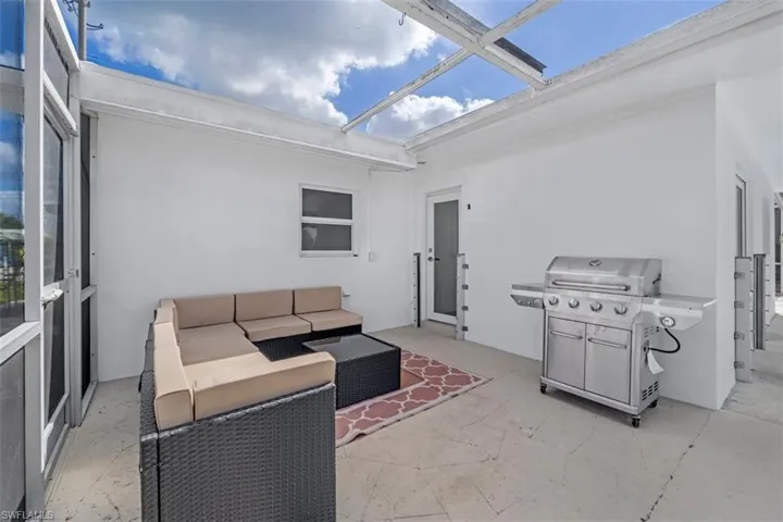 View of patio with an outdoor living space, area for grilling, and a sunroom