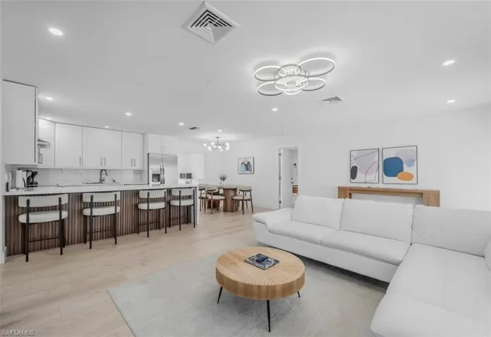 Living area featuring light wood-type flooring and suspended lighting