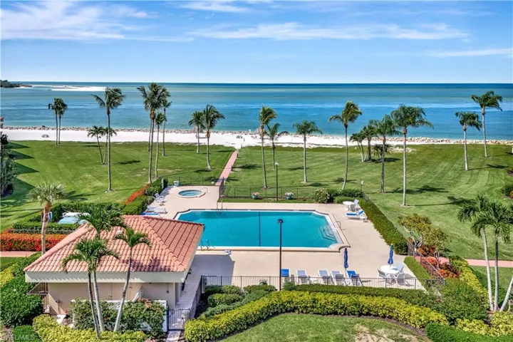 Community pool featuring a water view, a hot tub, and a patio area