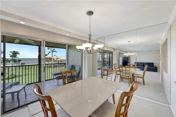 Dining room with a chandelier, a water view, crown molding, and recessed lighting