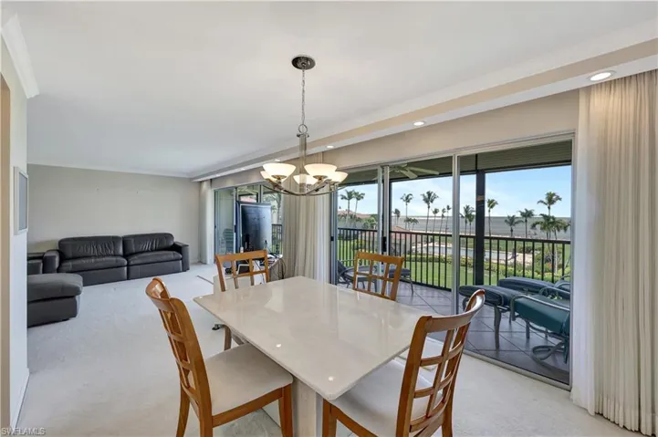 Dining area with a chandelier, light colored carpet, crown molding, and recessed lighting