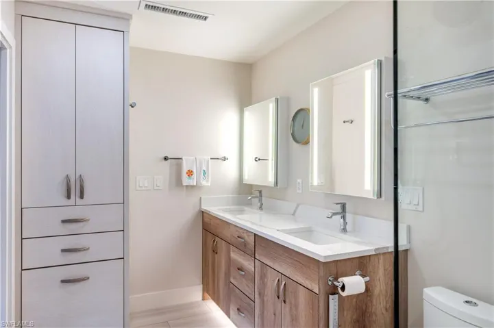 Bathroom featuring double vanity and a closet