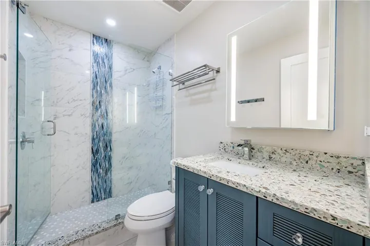 Full bath with vanity and a marble finish shower