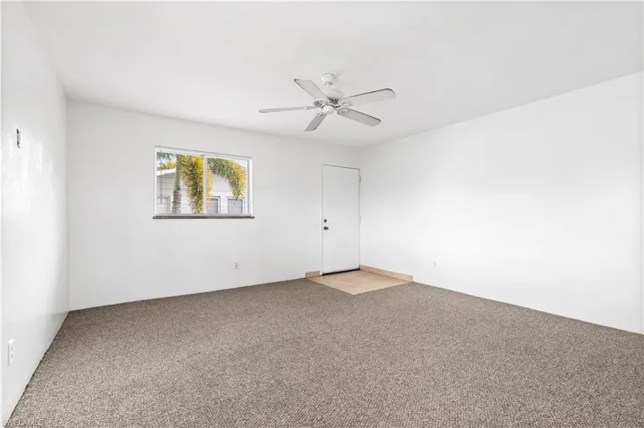 Carpeted spare room with ceiling fan