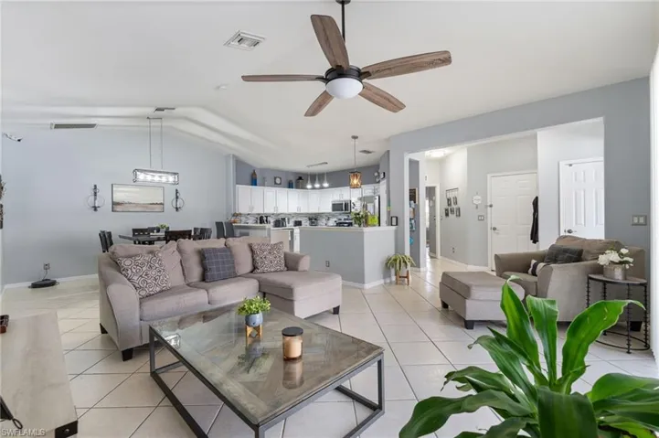 Living area with ceiling fan and light tile patterned floors