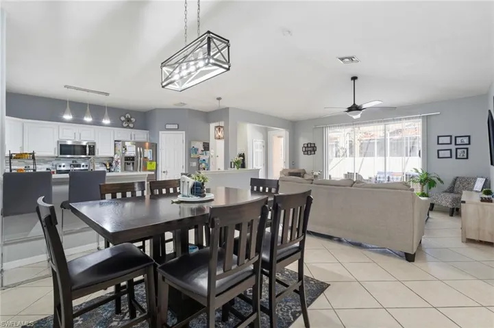 Dining area with light tile patterned floors, ceiling fan, and lofted ceiling