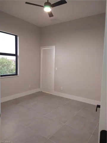 Tiled empty room featuring ceiling fan