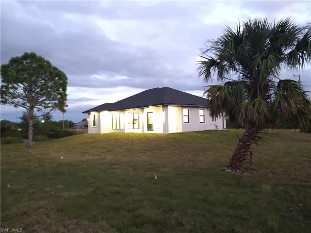 View of side of property featuring a lawn