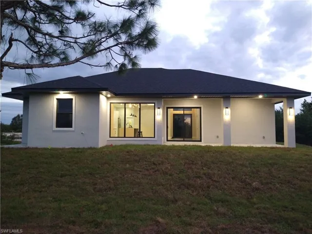 Rear view of property with a lawn