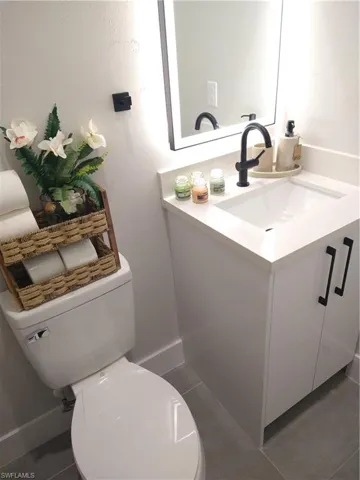 Bathroom featuring tile patterned flooring, vanity, and toilet
