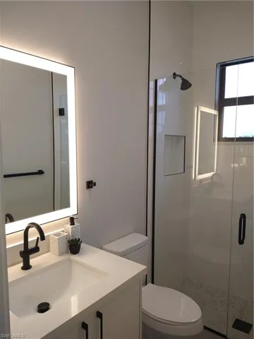 Bathroom with vanity, toilet, and walk in shower