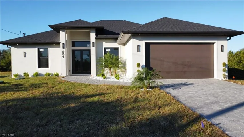 Prairie-style home featuring a front yard and a garage