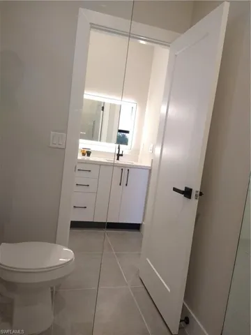 Bathroom featuring tile patterned flooring, vanity, and toilet