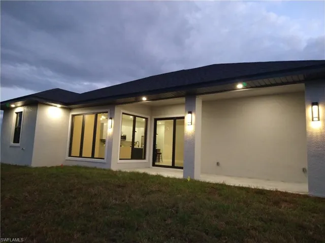 Back of house with a lawn
