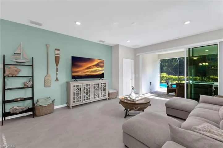 Tiled living room with recessed lighting and baseboards