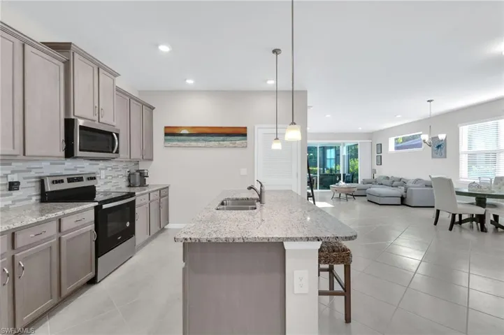 Kitchen featuring appliances with stainless steel finishes, light tile patterned flooring, gray cabinets, tasteful backsplash, and recessed lighting