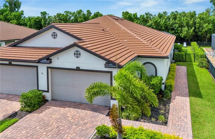 View of front of property with a tile roof, stucco siding, and decorative driveway