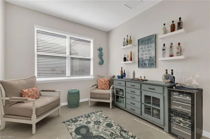 Sitting room featuring beverage cooler, a dry bar, and light tile patterned floors